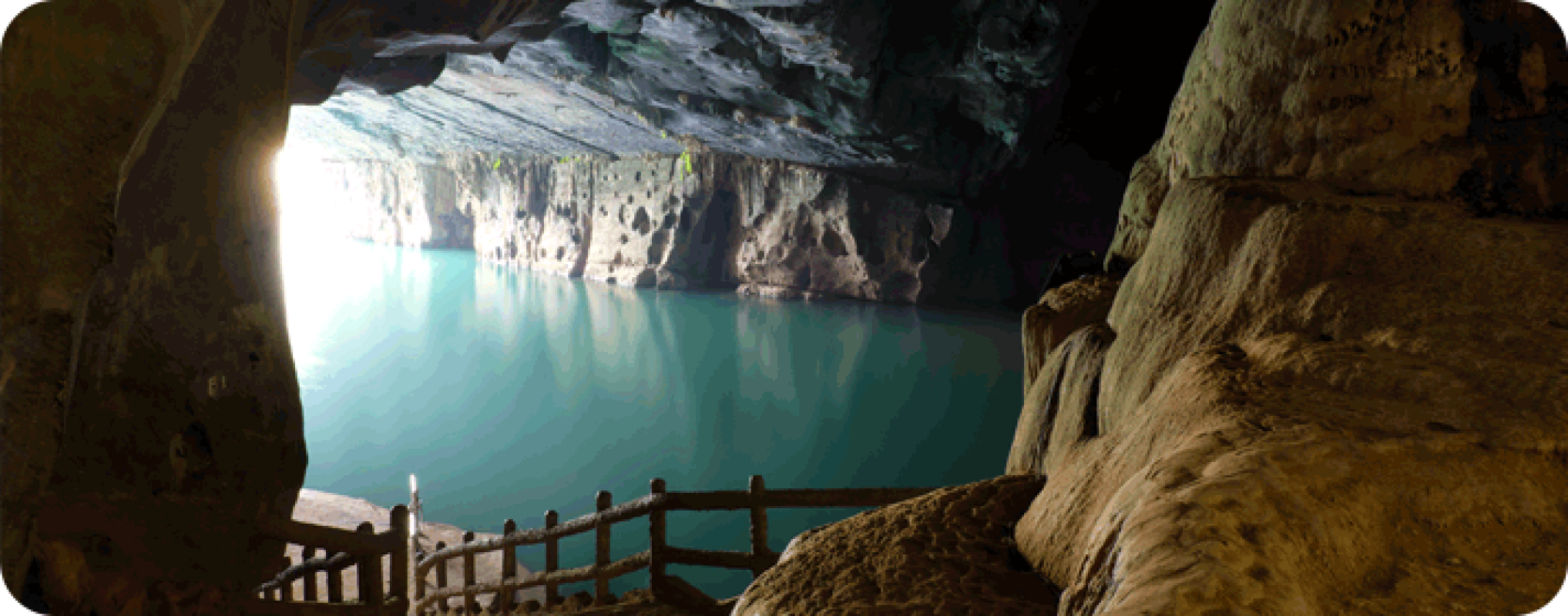 A view of a cave with a blue water pool inside